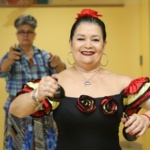 A close-up image of an older adult smiling and dancing.