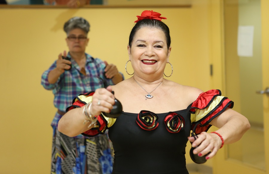A close-up image of an older adult smiling and dancing. 