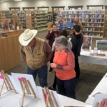 Older adult participants look at artwork during a culminating event at a Wyoming public library.